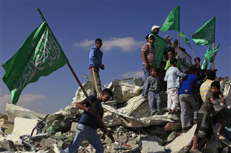 Israeli Arab youths, holding green Islamic flags, stand on the rubble of a mosque, demolished by the Israeli police, in the Bedouin city of Rahat, southern Israel, on Sunday.